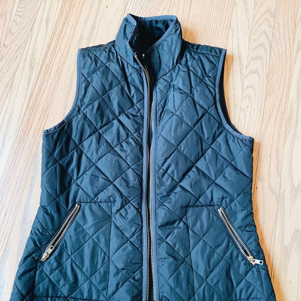 Black quilted vest with gold zippers